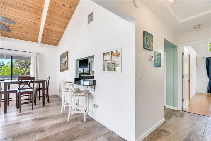 Dining room featuring wooden ceiling, baseboards, visible vents, and wood finished floors