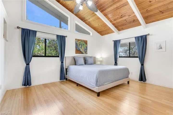Bedroom with beamed ceiling, wood finished floors, wood ceiling, and baseboards