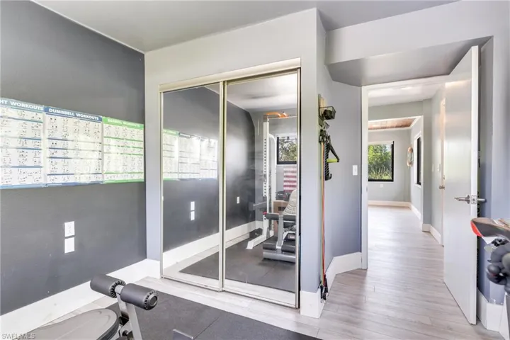 Exercise room featuring wood finished floors and baseboards