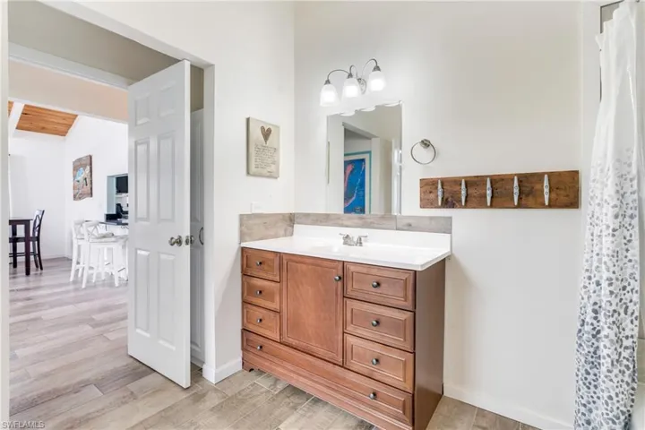 Full bath with wood finished floors and vanity