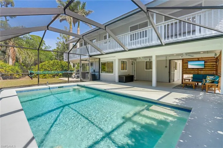 Pool with a lanai, a patio area, ceiling fan, and an outdoor living space