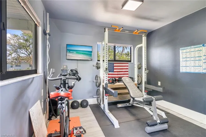Exercise area featuring wood finished floors, a wealth of natural light, and baseboards