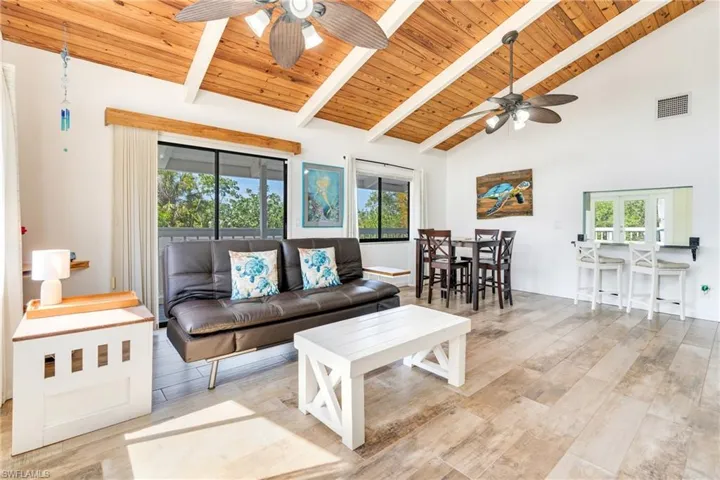 Living room with beam ceiling, wooden ceiling, wood finished floors, and visible vents