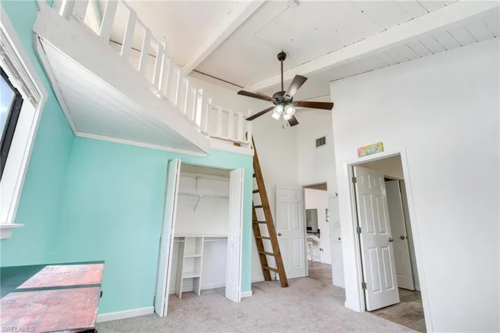 Bedroom with a closet, carpet flooring, beamed ceiling, and visible vents