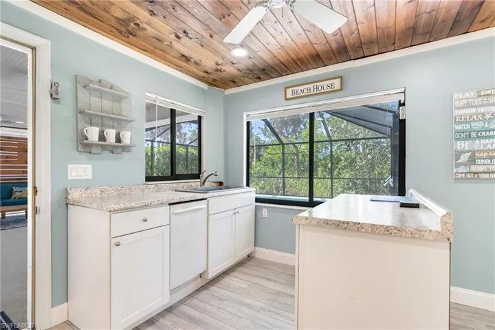 Kitchen featuring a sink, wood ceiling, light wood-style floors, white cabinetry, and dishwasher