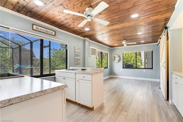 Kitchen featuring wood ceiling, light wood-style floors, a barn door, and light countertops