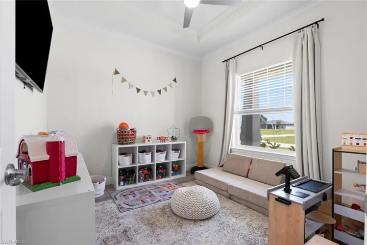 Rec room featuring ceiling fan and crown molding
