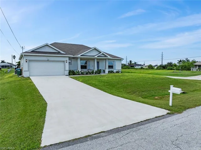View of front of home with a front yard and a garage
