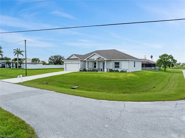 Ranch-style home with a front yard and a garage