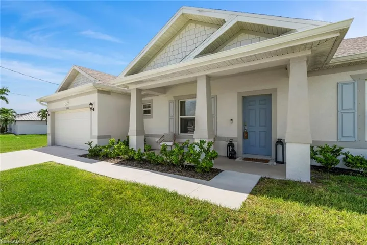 View of front facade with a porch, a front yard, and a garage