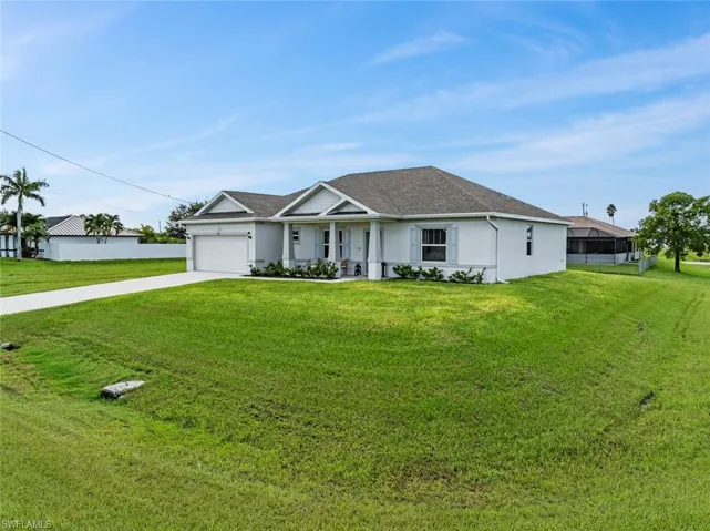 Single story home with a garage and a front yard