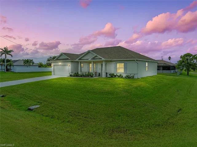 Single story home featuring a yard and a garage