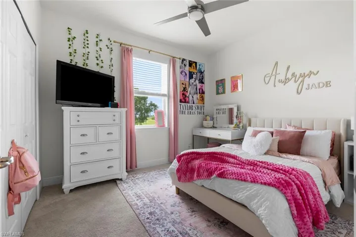 Carpeted bedroom featuring ceiling fan and a closet