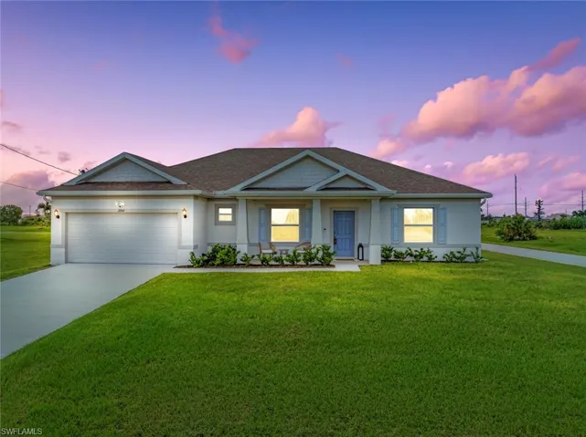 View of front of property featuring a yard and a garage