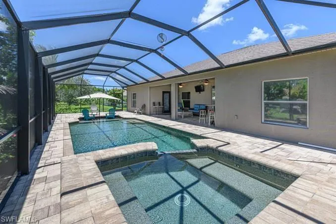 View of swimming pool with a patio, ceiling fan, and a lanai