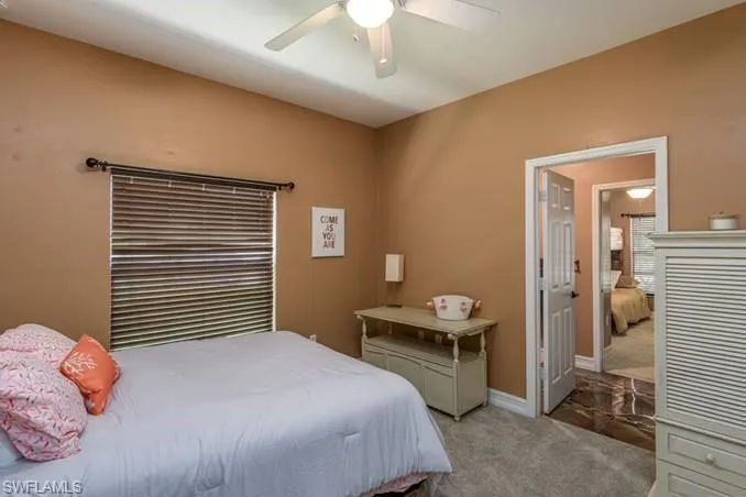 Bedroom with ceiling fan and light colored carpet