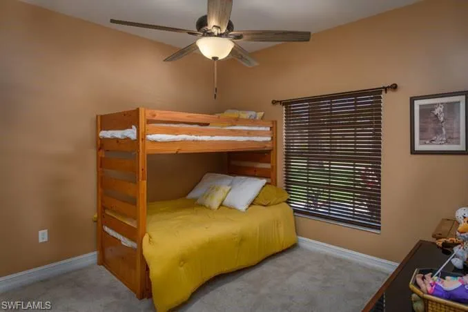 Carpeted bedroom featuring ceiling fan