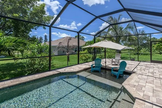 View of swimming pool featuring a patio area, a lanai, and a lawn