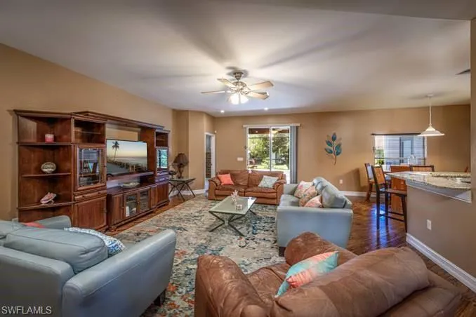 Living room featuring ceiling fan and dark hardwood / wood-style floors
