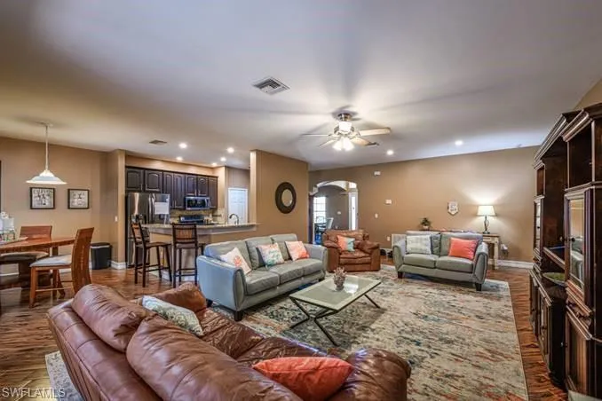 Living room featuring ceiling fan and dark hardwood / wood-style floors
