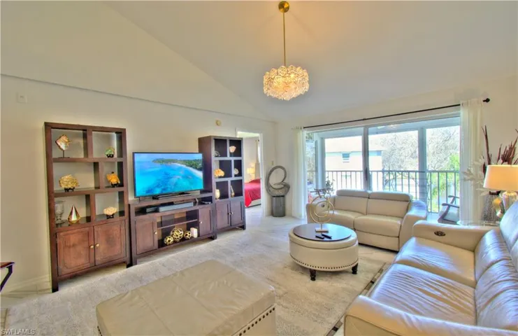 Living room featuring vaulted ceiling and hanging lights
