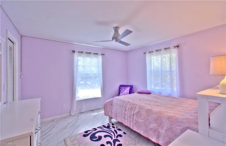 Bedroom with light marble finish flooring and ceiling fan
