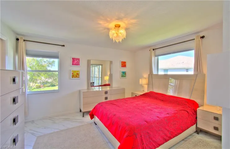 Bedroom with hanging lights and marble finish floors