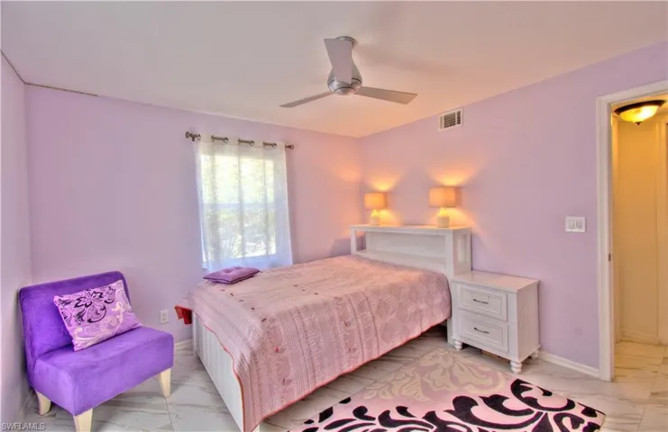 Bedroom featuring light marble finish floors and ceiling fan