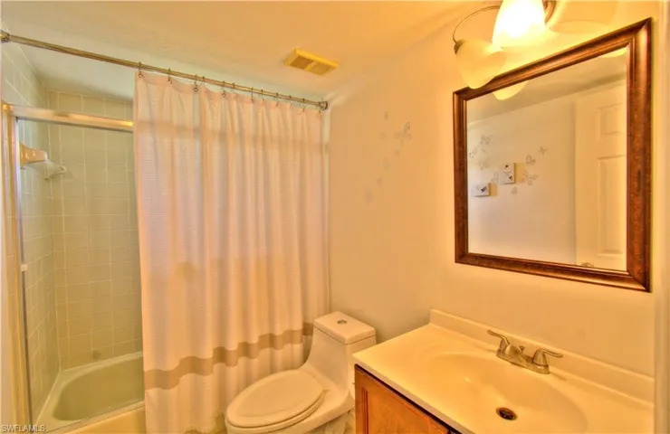 Bathroom featuring vanity and shower / bathtub combination with curtain