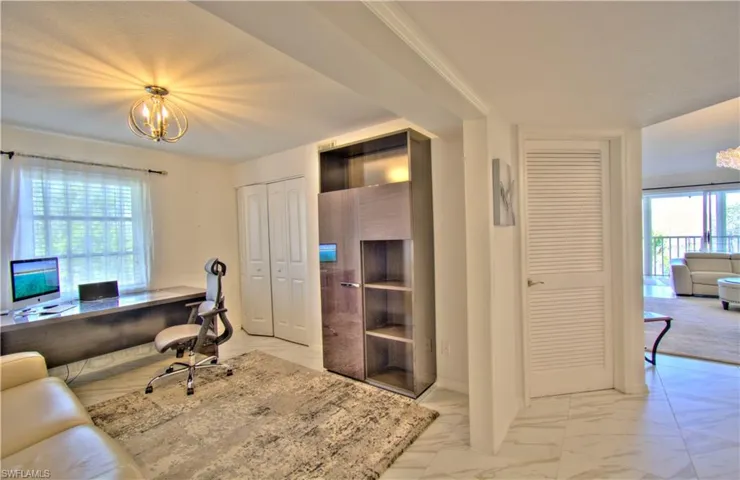 Home office featuring hanging lights and light marble finish floors
