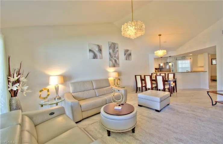 Living area with lofted ceiling and suspended lighting