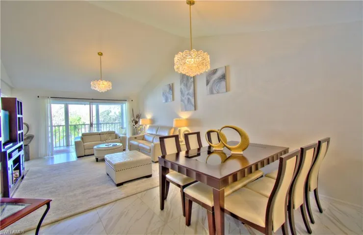 Dining room featuring a chandelier, a high ceiling, and light marble finish floors