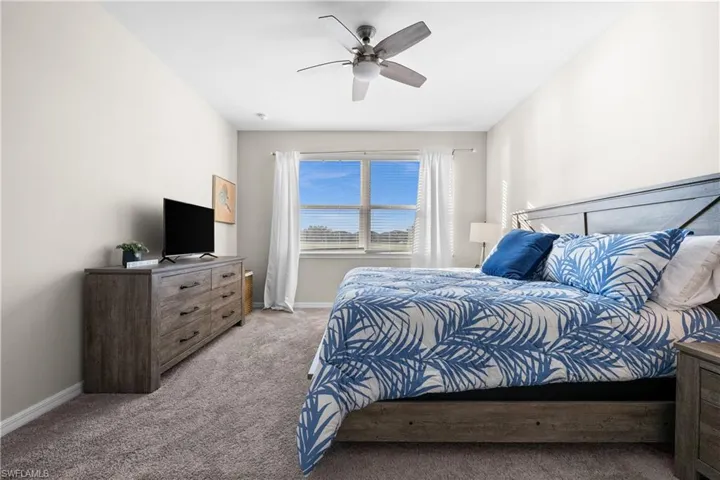 Carpeted bedroom with ceiling fan