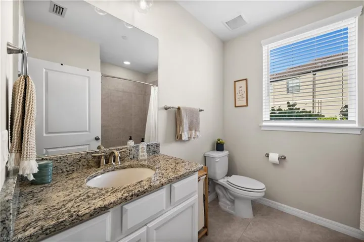 Bathroom featuring tile patterned floors, vanity, curtained shower, and toilet