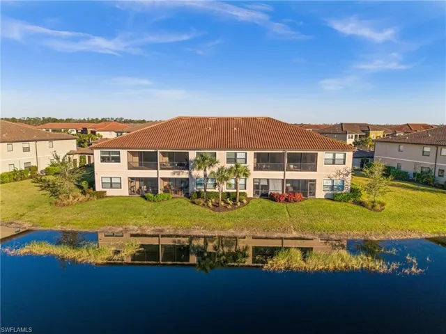 Rear view of house with a lawn and a water view