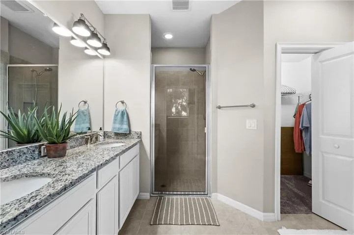 Bathroom with tile patterned floors, vanity, and an enclosed shower