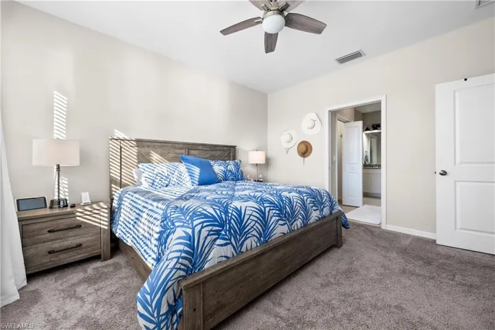 Bedroom featuring connected bathroom, ceiling fan, and carpet