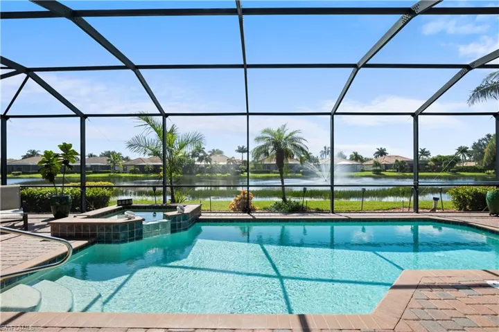 Screened outdoor living area with a pool and integrated spa
