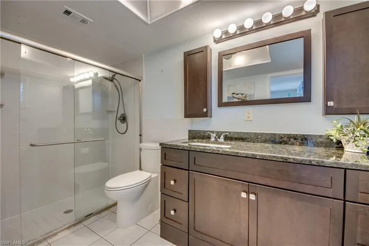 Primary ensuite bathroom has tiled shower, granite topped vanity and linen closet.