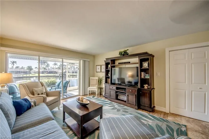 Easy access to lanai and dock via triple sliders. Workshop/storage closet is behind the bi-fold doors on the right.
