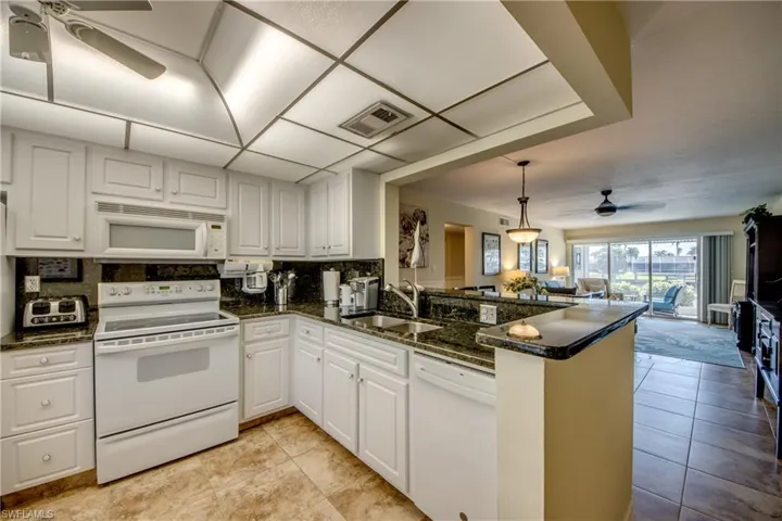 Granite counters and backsplash highlight this large kitchen, which is open to the dining area for ease of  entertaining.