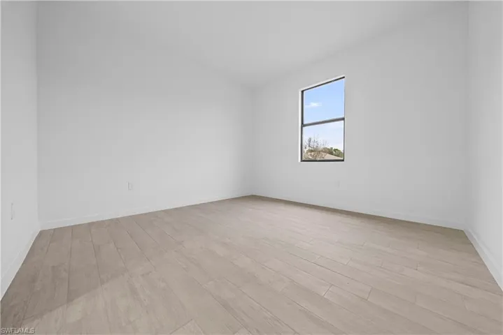 Unfurnished room with light wood-style floors and baseboards