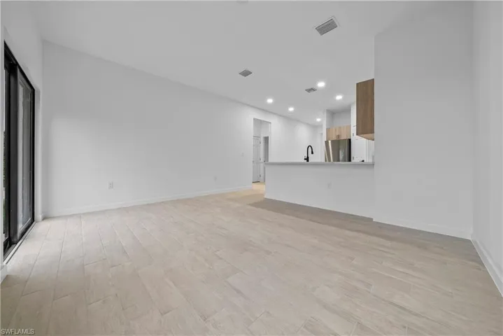Unfurnished living room with light wood-type flooring and recessed lighting