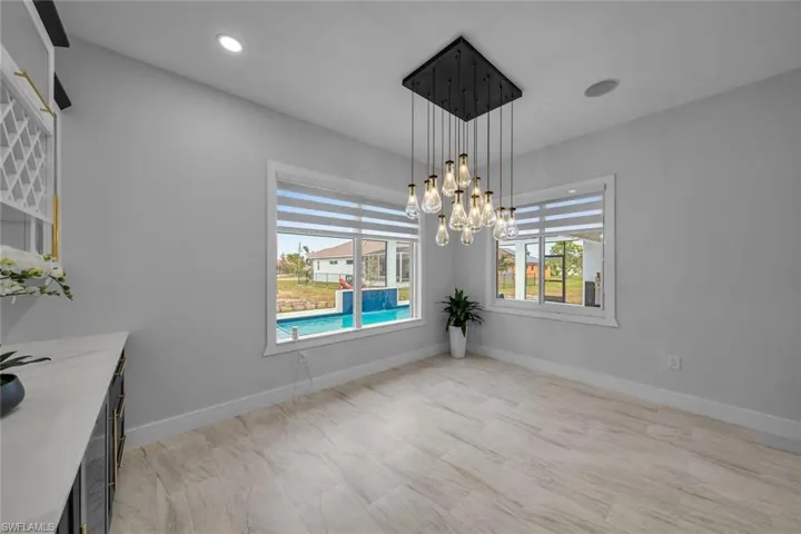 Unfurnished dining area with baseboards, an inviting chandelier, and recessed lighting