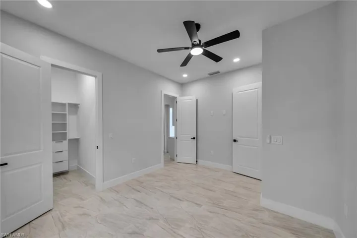 Unfurnished bedroom featuring recessed lighting, a spacious closet, marble finish floor, visible vents, and baseboards