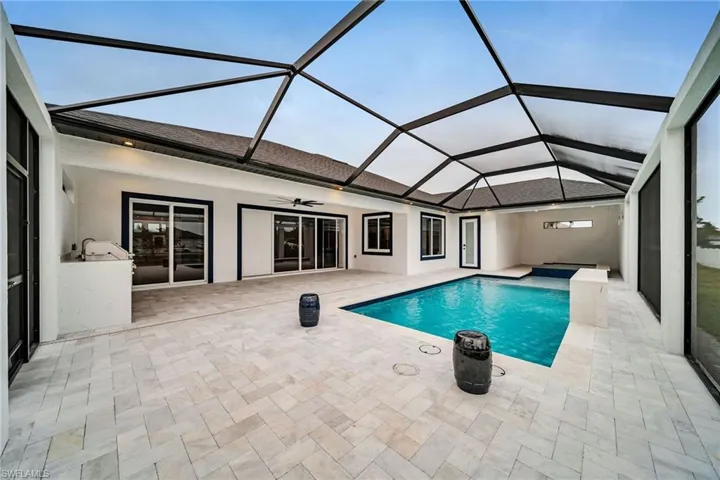 Outdoor pool featuring a patio area, a lanai, a ceiling fan, and area for grilling