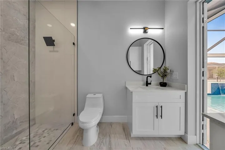 Full bathroom with baseboards, toilet, vanity, and a stall shower