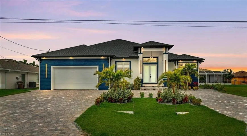 Prairie-style house with a shingled roof, a yard, central air condition unit, an attached garage, and decorative driveway