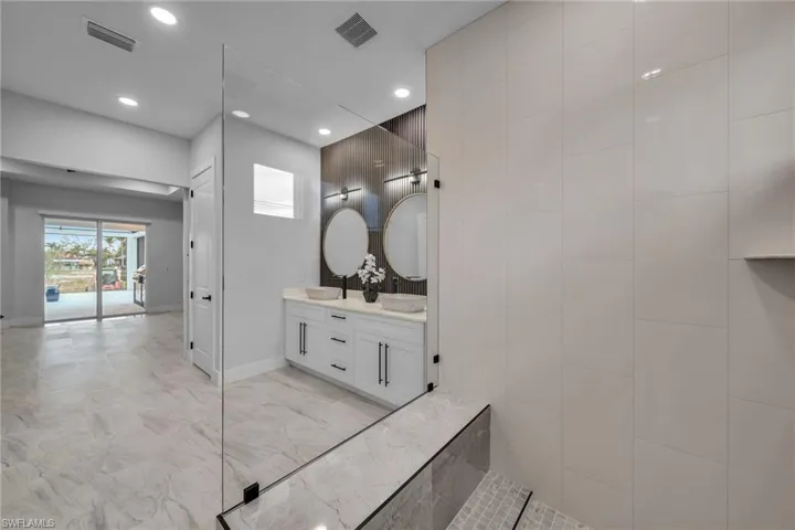 Bathroom featuring recessed lighting, visible vents, and a sink