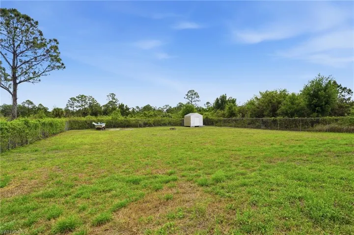 Fenced yard featuring a shed